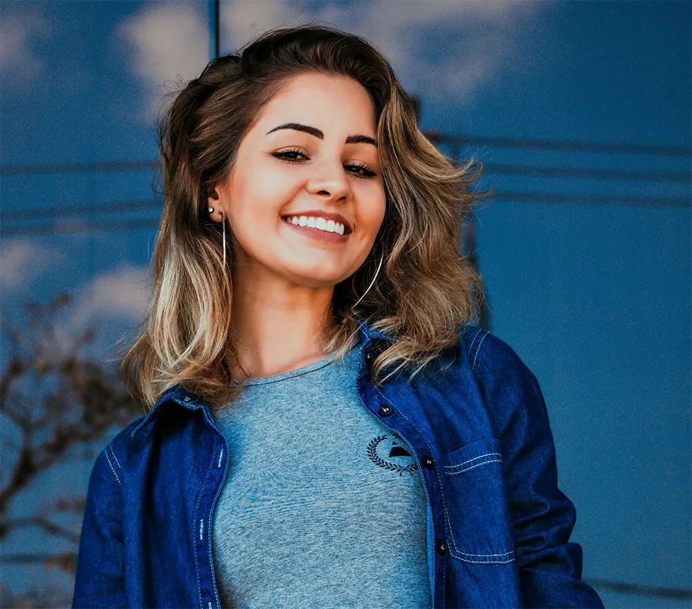 Young female blonde in denim jacket smiling