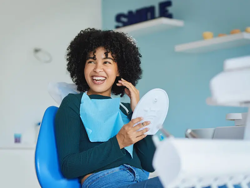 Young African American female in dental chair smiling